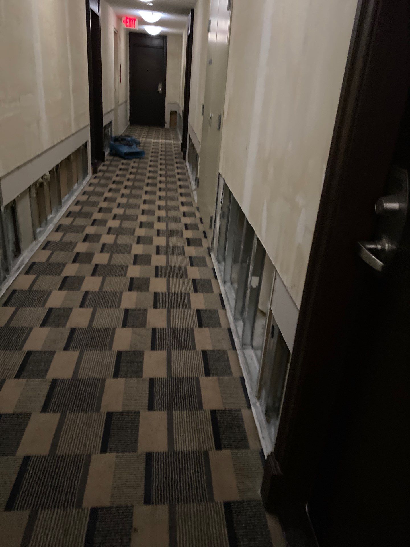 Corridor drywall cut open during water damage remediation — rebuild contractor GTA